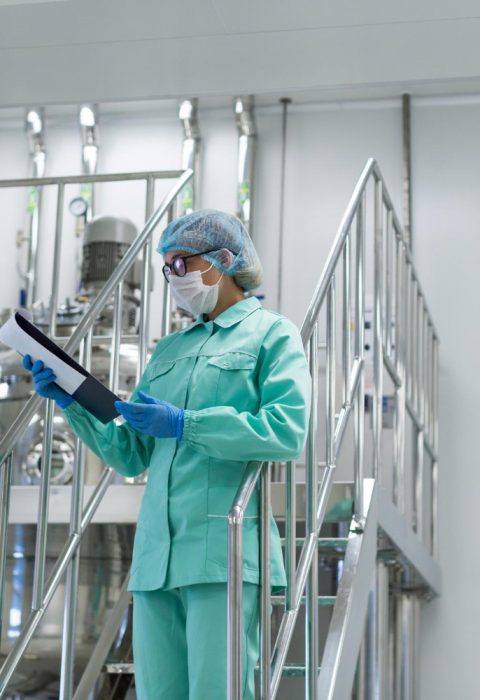 scientist-woman-in-blue-suit-looking-in-tablet-standing-on-stairs